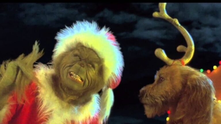 el grinch mirando hacia un pueblo nevado