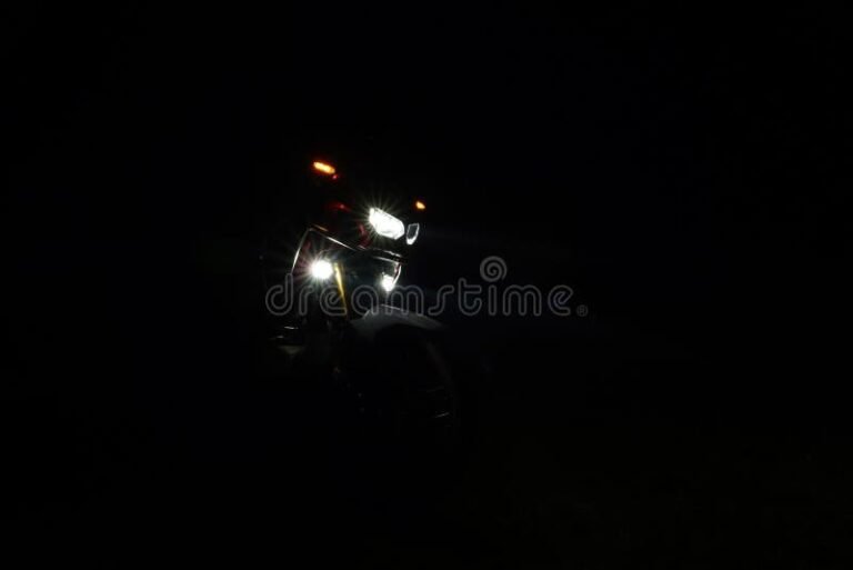 Qué son los faros con lupa para moto y cómo mejoran la visibilidad 22 faros de moto iluminando un camino oscuro