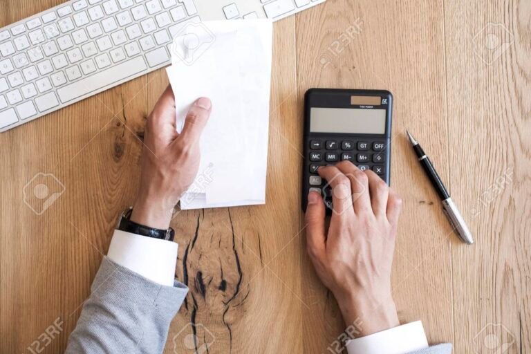 manos sosteniendo facturas en un escritorio