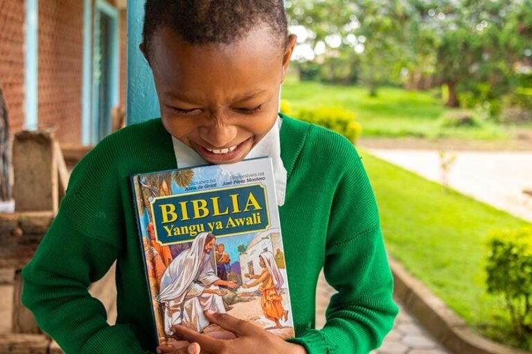 nino leyendo biblia ilustrada en un jardin