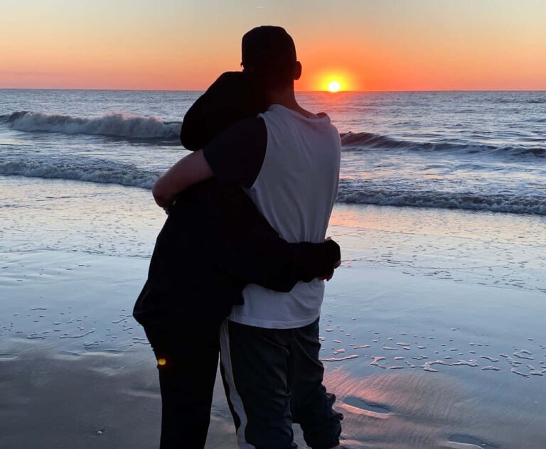 pareja abrazandose bajo un atardecer