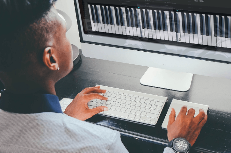 Cómo tocar piano usando el teclado de una computadora 7 persona tocando piano en una computadora