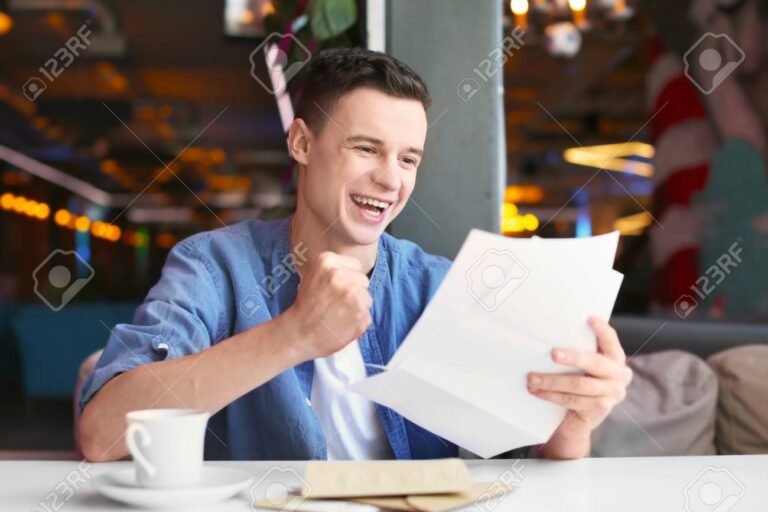 un joven leyendo cartas en una mesa